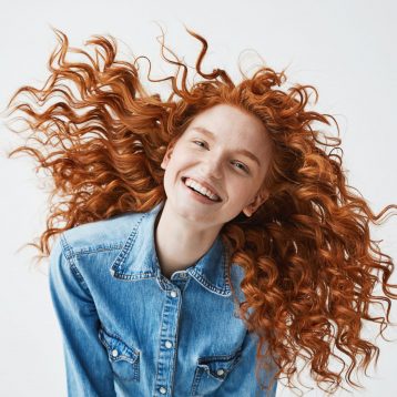 Pretty,Cheerful,Redhead,Girl,With,Flying,Curly,Hair,Smiling,Laughing